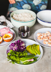 Poke bowl with shrimp prepared by the chef containing white rice, mango, avocado, tomato, etc.