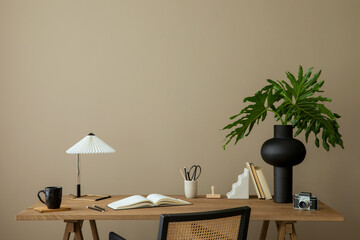 Minimalist composition of workplace interior with wooden desk, rattan chair, books, vase with...