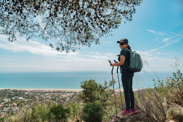Happy hiker in the mountains and the Mediterranean coast in the background.