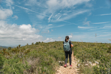 Woman enjoying a leisurely stroll through majestic mountain terrain.