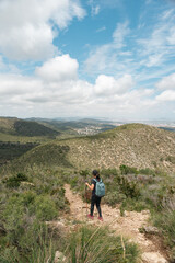Adventurous woman walking up steep mountains on a clear day.