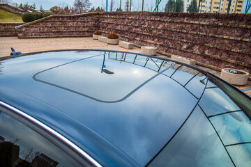 Reflection of the sky on the roof of a car with a sunroof
