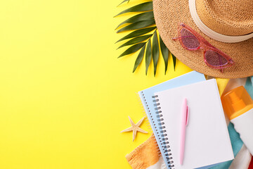 Summer vacation essentials including hat, notebook, and sunscreen on yellow background. Ideal for travel blogs and vacation promotions