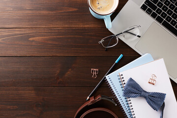 Office desk with coffee, glasses, laptop, and bow tie. Ideal for business, work from home, or...