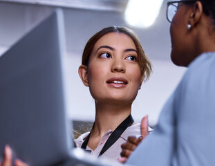 Women, laptop and communication in server room for IT, cybersecurity and collaboration in workplace. Female programmers, computer and discussion with technician for brainstorming, plan and issues