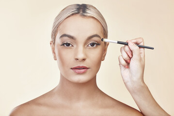 Fototapeta premium Woman, portrait and hand with brush for makeup with eye product, skincare beauty and eyeshadow. Model, beautician and cosmetics tool with cosmetology and face powder application on studio background