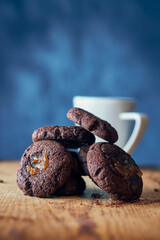 Pile of carob seeds with white cup on blue background