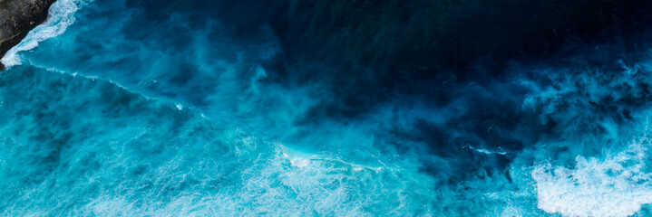 Banner Turquoise ocean sea water white wave pattern splashing deep blue sea. Banner Tropical sea beach Seascape dark background wave splash on rock. Summer Ocean Surface big wave with copy space