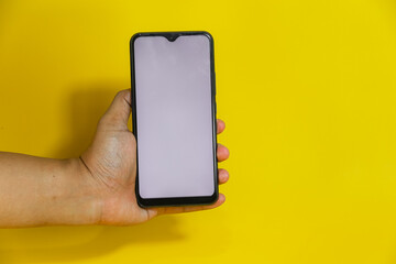 hand hold a smartphone white screen isolated on yellow background