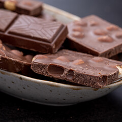 Chocolate cupcake with icing and chocolate bar in Dark lighting,Homemade delicious chocolate muffin on wooden background close-up