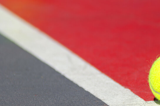 partial view of a ball on a tennis court, racket sports
