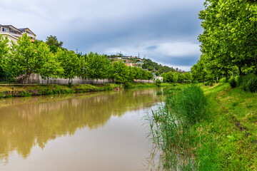 A view along the River Drin towards from a pedestrian bridge at Lezhe, Albania in summertime