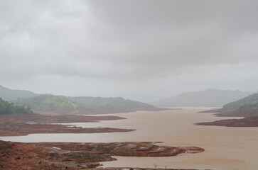Dark clouds and rain storm over the river, rainy season in Bhor, Maharashtra, India, Asia.