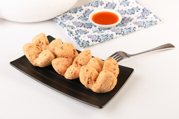 Bakwan Goreng or fried meatballs made from chicken and shrimp typical of Surabaya, shaped like a flower and served with spicy sauce
