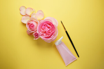 Creative flat lay composition with rose flowers on yellow background, top view. Creative concept....