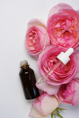 Product for skincare based on rose oil, essential oil solution in dropper bottle. Brown pipette...