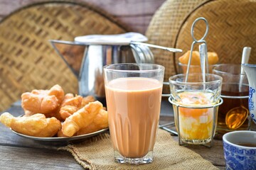 Thai traditional Breakfast set hot milk tea with hot tea and deep fried dough stick , youtiao, thai called Patongko