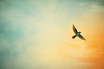 Fototapeta premium A solitary bird soars through a vibrant sky at sunset, with hues of orange and blue blending beautifully in the background.