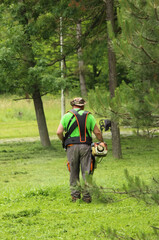 Man trimming the grass in the park