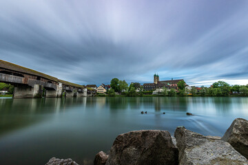 Fototapeta premium skyline of bad säckingen germany with reflection of the ancient wooden bridge and saint fridolin church in the river rhine 