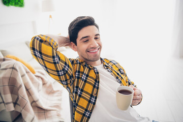 Photo of cool good mood man wear checkered shirt staying home drinking coffee relaxing indoors...