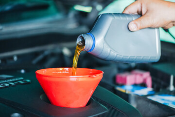 mechanic is seen refilling engine lubricant with precision and care. 