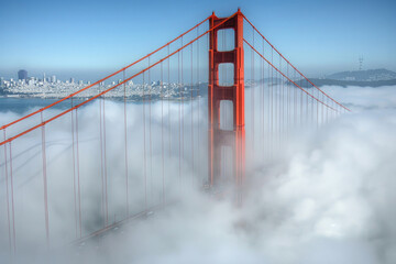 The Golden Gate Bridge partially shrouded in fog with its iconic red towers visible