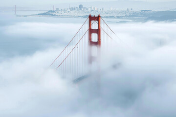 The Golden Gate Bridge partially shrouded in fog with its iconic red towers visible