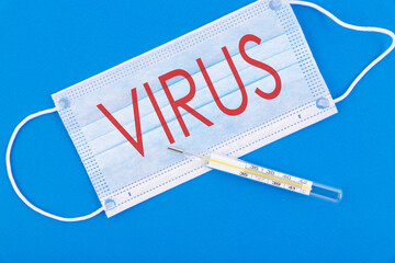 The word virus is written on a protective mask. Top view.