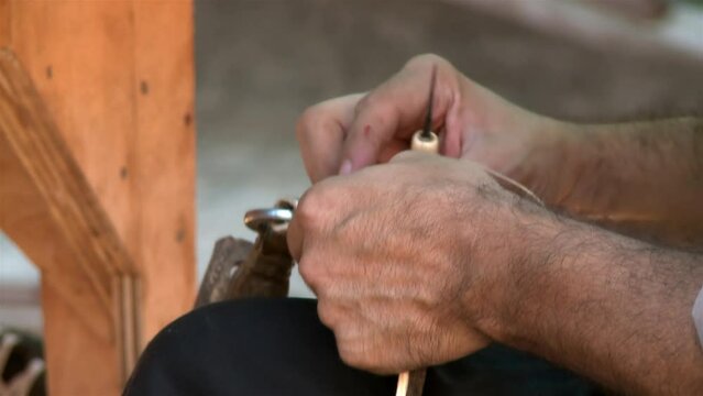 An Argentine Gaucho Repairing Horse Bridles in his Country House. Close Up.
