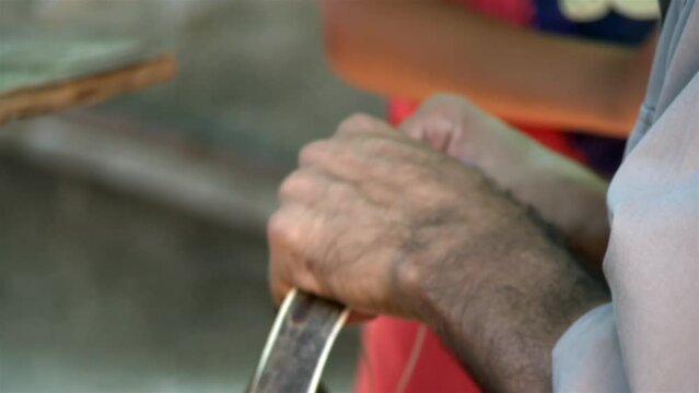 An Argentine Gaucho Repairing Horse Bridles in his Country House. Close Up.