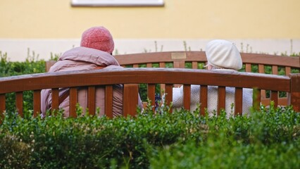 Two Elderly Women Sitting on Park Bench Talking about Everyday Life Joy and Problems