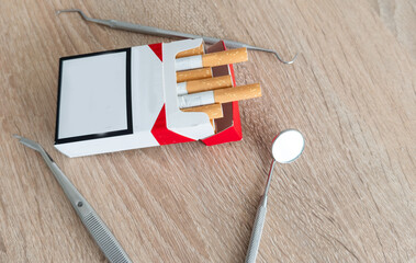 Image of dental tools with cigarettes on the table background