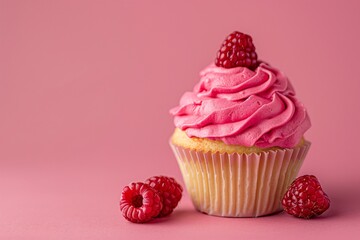 a cupcake with pink frosting and raspberries