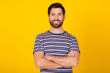 Portrait photo of handsome confident young successful businessman in striped t shirt folded hands...