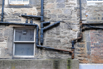 Pipes on Exterior of Old Stone Building 