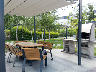 Blurred picture of blank wooden table and chairs with barbecue area