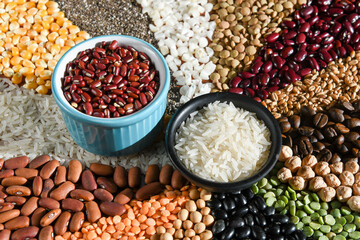 Bowl with raw white rices and beans on various seeds grain