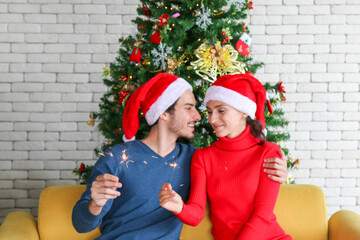 Couples are celebrating together in the new year or chrismas party with sparklers light, Both of them smile happily.