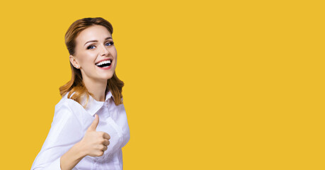 Portrait of happy smiling excited businesswoman, showing thumb finger up or like hand sign gesture....