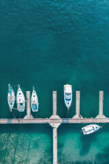 Aerial view of a minimalist marina with neatly arranged boats and docks. Focus on the clean lines and repetitive patterns, using a limited color palette to enhance the minimalist aesthetic. 