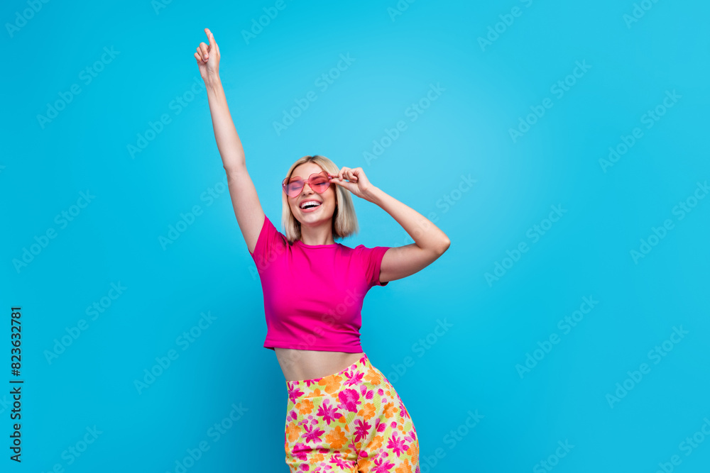 Poster Photo portrait of attractive young woman sunglass dancing good mood dressed stylish pink clothes isolated on blue color background