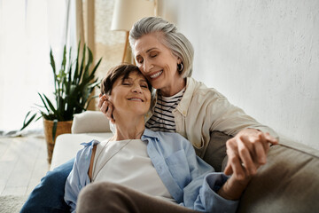 Two sophisticated elderly women relaxing together on a comfortable couch.