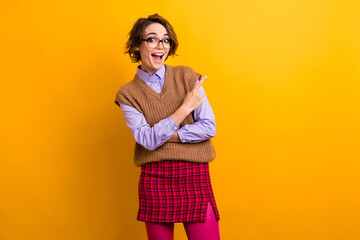 Photo of ecstatic girl with bob hairdo dressed knit waistcoat indicating at awesome sale empty...