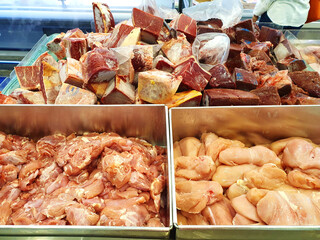Fresh cuts of raw chicken and beef on display in supermarkets