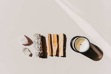 White sage and Palo Santo and amethyst and quartz crystals on a light beige background.