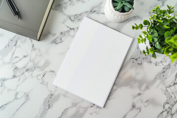White notebook, plant, marble table