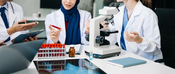 Doctor Talks With Professional Head Nurse or Surgeon, They Use Digital tablet Computer. Diverse Team of Health Care Specialists Discussing Test Result on desk .