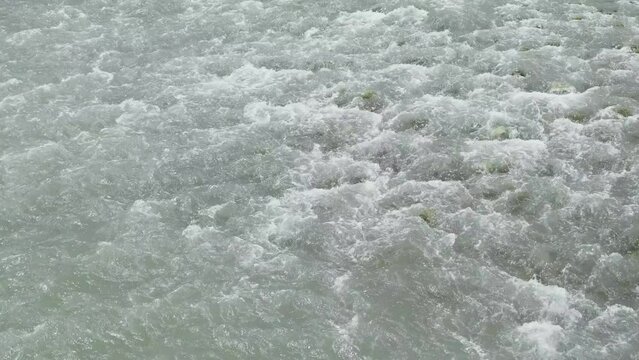 rapid flow of water among rocks in mountain river close-up, slow motion
