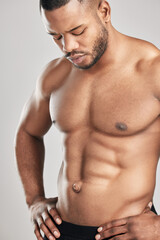 Fototapeta premium Male bodybuilder, topless and muscle in studio for wellness, healthy body and six pack on gray background. Black man, fitness and performance or strength for health with masculine and confidence